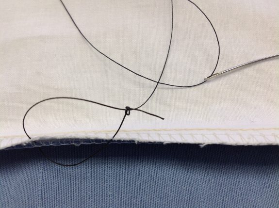 Thread needle through loop in knot