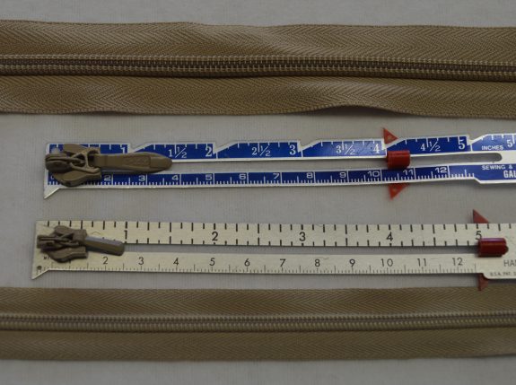 This photo shows the comparison between a size #5 and size #3 invisible zipper and the size of the zipper pulls. I like to consider the size of the pulls because in a well sewn invisible zipper next to welt cord, the only thing that shows is the zipper pull.